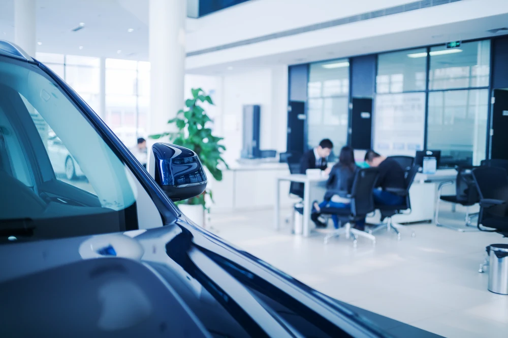 Gros Plan De Vendeur De Voiture Donnant Des Clés À Un Client Mâle Dans Un Showroom