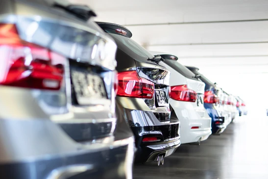 Parking ext&eacute;rieur avec rang&eacute;es de v&eacute;hicules stationn&eacute;s sous &eacute;clairage naturel